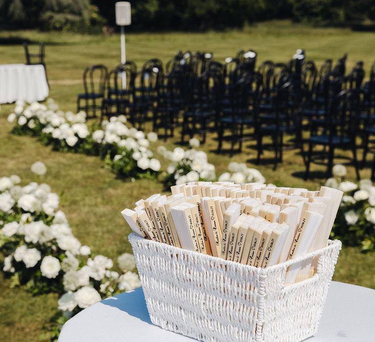 Box of fans for guests at hot summer outdoor wedding ceremony 