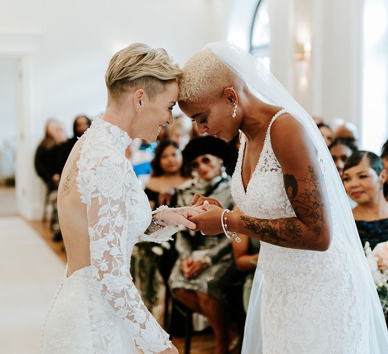 Two brides in lace gowns at their wedding ceremony in Wales 