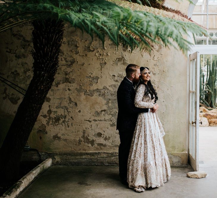 Bride and groom embracing at black tie wedding