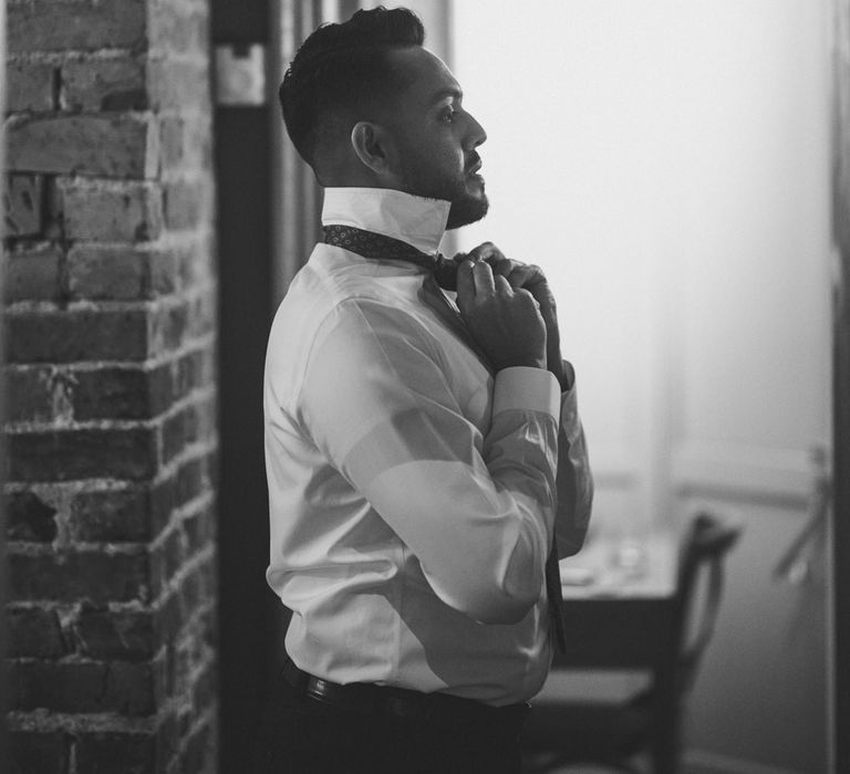 Groom fitting tie getting ready for Chelsea town hall wedding 