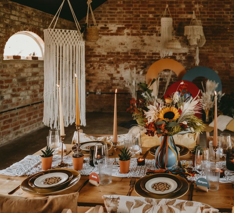 70s tablescape decoaration with sunflowers, patterned tableware and candles 