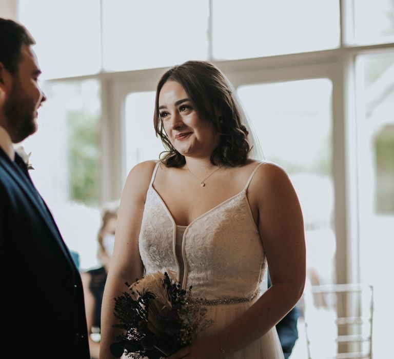 Smiling bride and groom at the altar