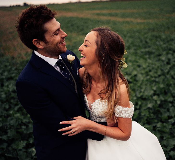 Bride and groom celebrating at countryside wedding with cold shoulder wedding dress