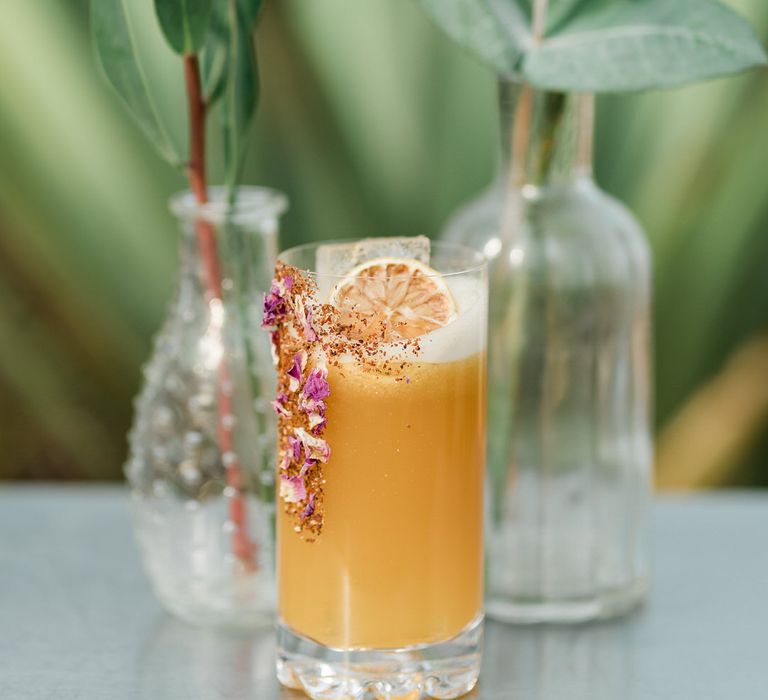 Orange cocktail drink with botanical wedding flowers at Urban Jungle Suffolk