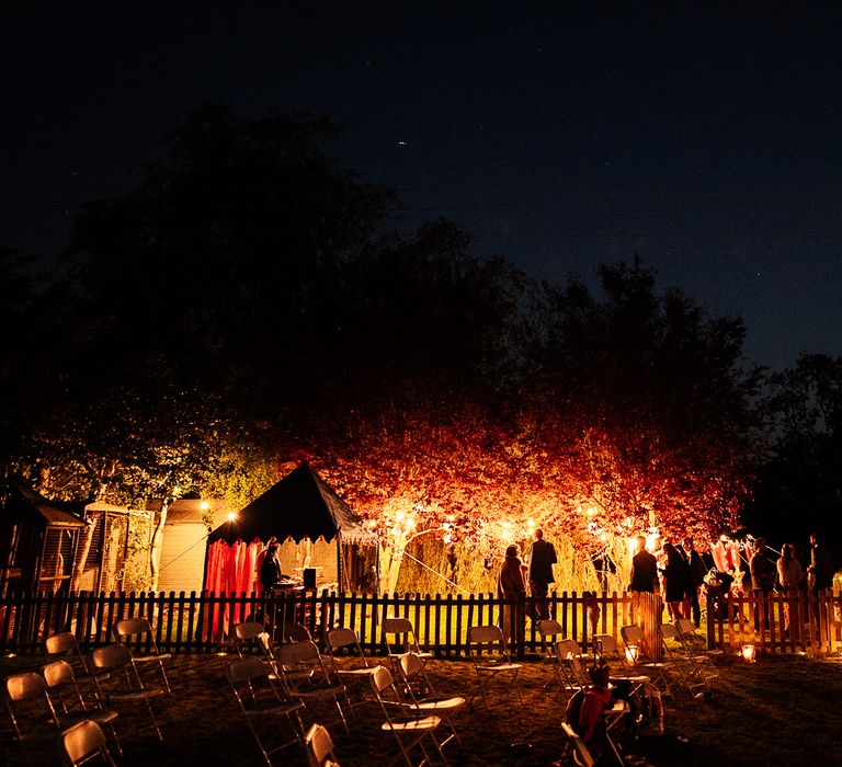 Wedding garden party lit up with fairy lights within the trees