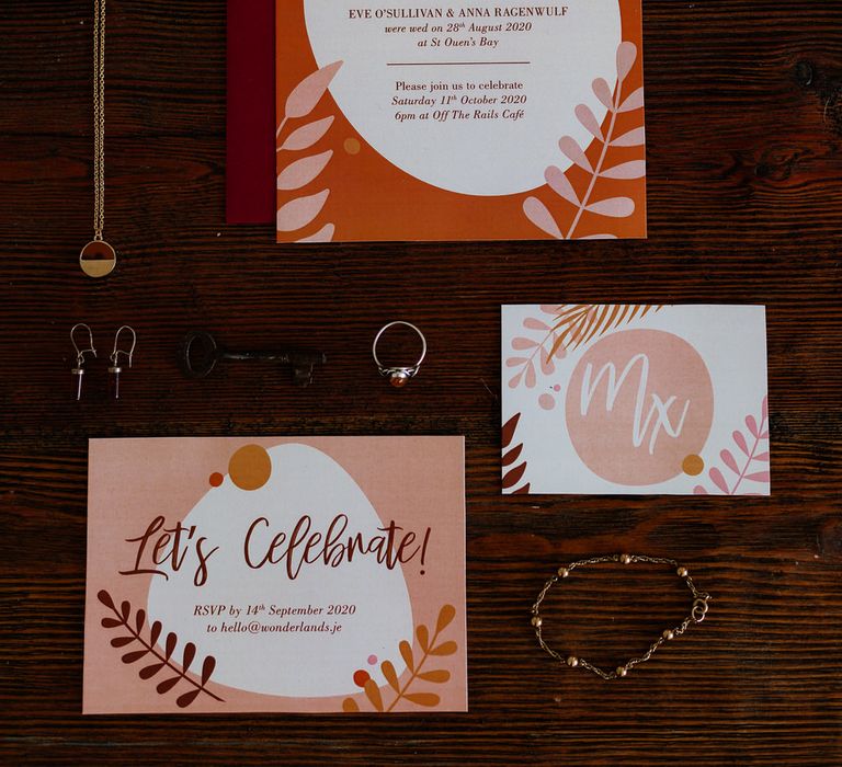 Orange 'we eloped' stationery flatlay with jewellery