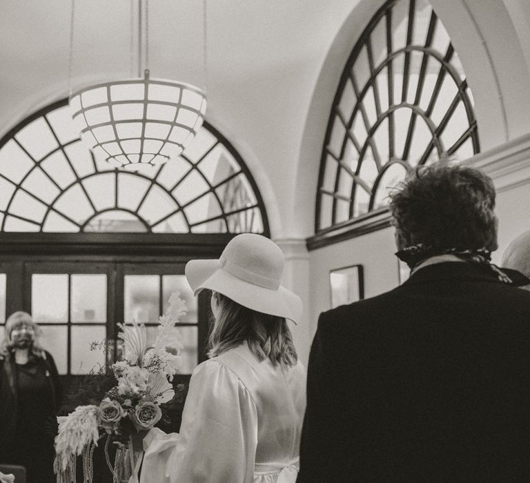 Bride walks through Chelsea Town Hall in black & white image