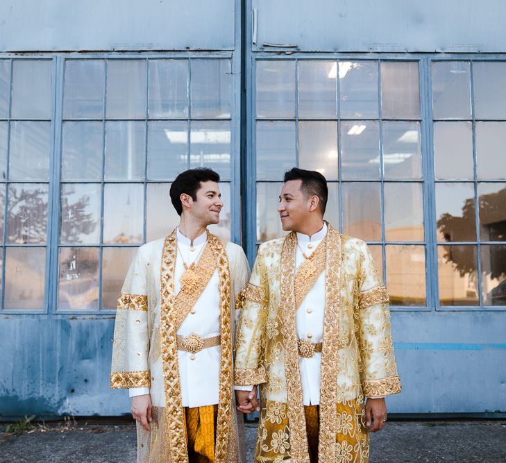 A gay couple pose for a portrait at their wedding. They both wear traditional Cambodian outfits. Photography by Beatrici Photography. 