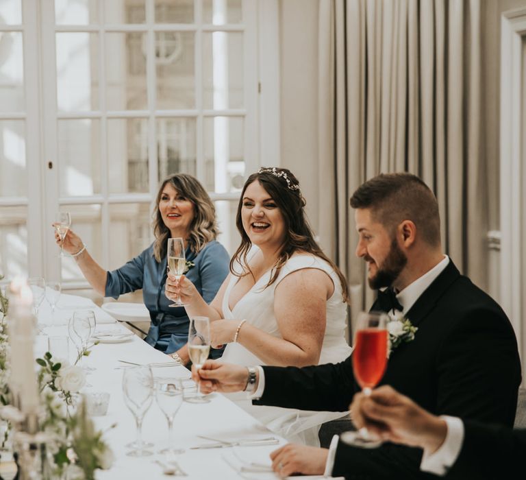 Wedding guests laugh around the table during wedding reception at The Landmark London hotel