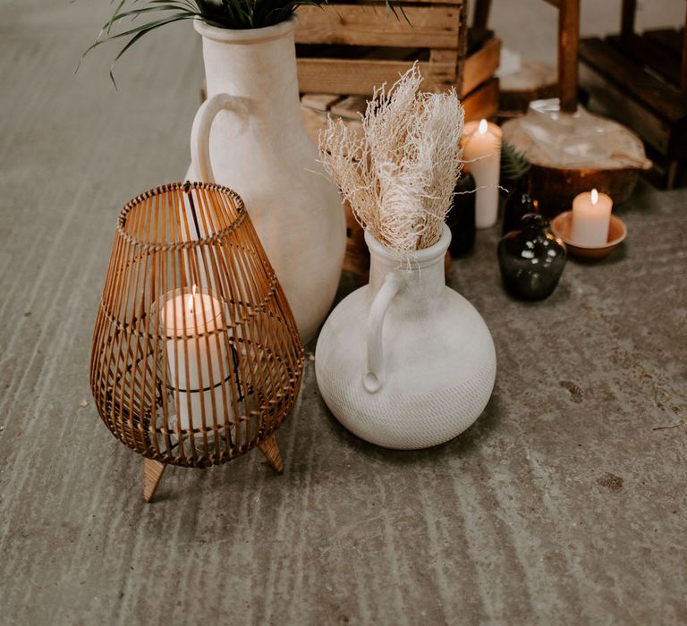 Tropical wedding decor with rattan candle holders, ceramic vases and tropical plants