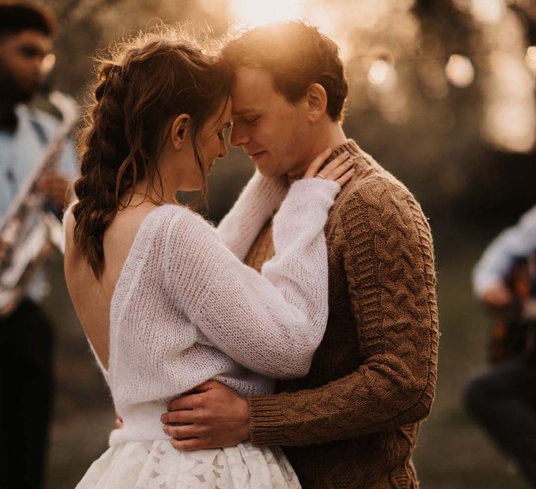 Intimate golden hour bride and groom portrait in knitwear casual wedding attire 