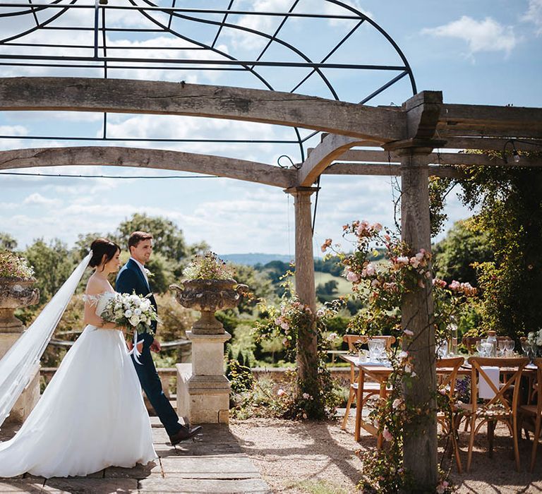 Bride & groom walk through the grounds of Euridge Manor on their wedding day