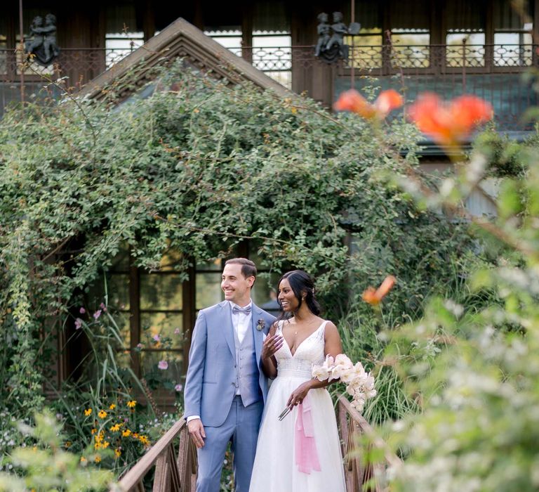 Bride & groom walk across wooden bridge with one another after wedding ceremony