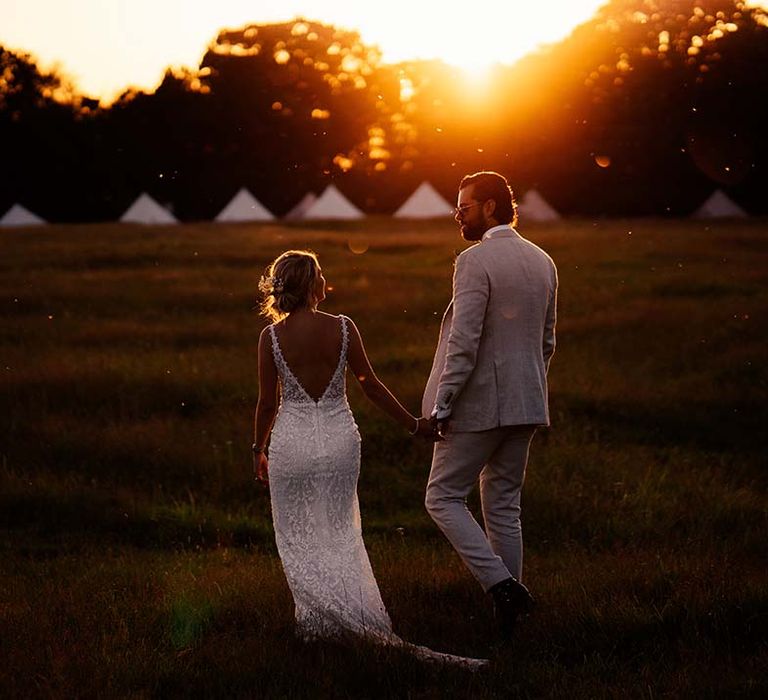 Bride and groom walk hand in hand during sunset at Preston Court