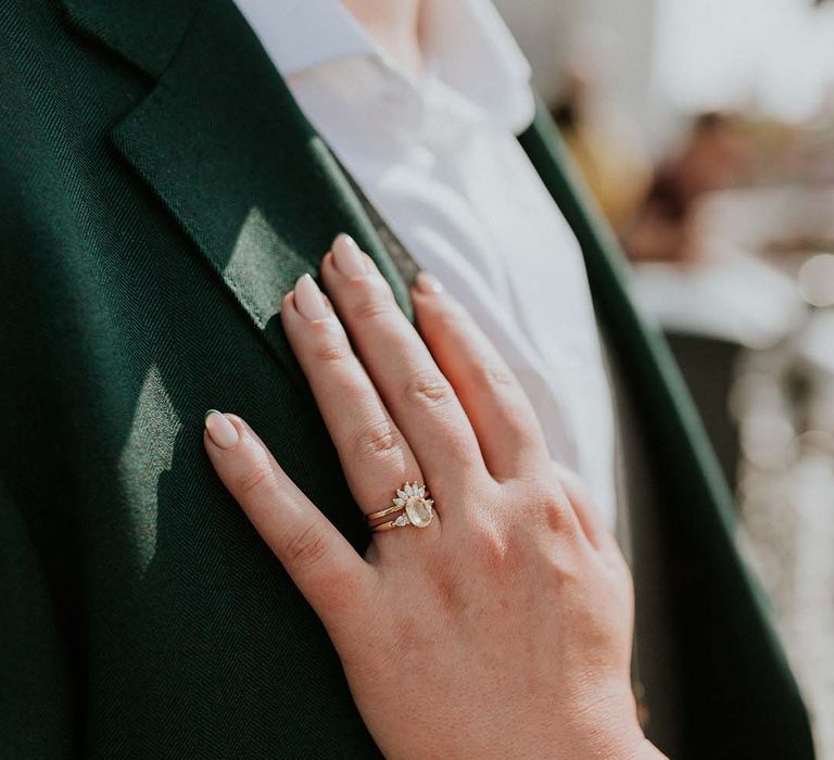 Bride places her hand on grooms jacket complete with vintage styled engagement ring and green tipped French wedding nails