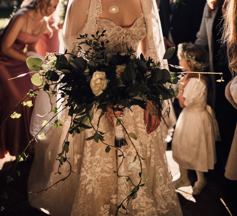 Bride stuns in lace trim veil with low bun hairstyle