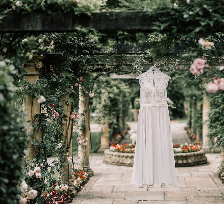 Boho chic wedding gown hangs from pergola 