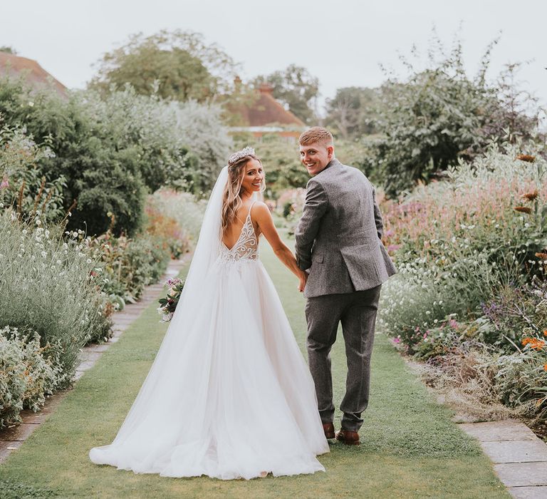 Bride and groom walk in the gardens at country house wedding venue