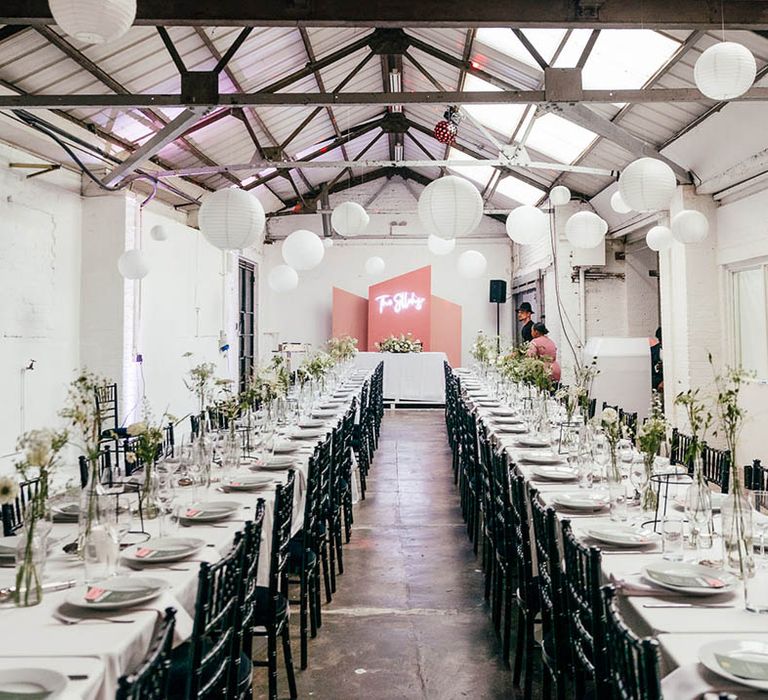 Pink, grey and white colour scheme with pink backdrop, white neon sign, hanging paper lanterns and white tablecloth