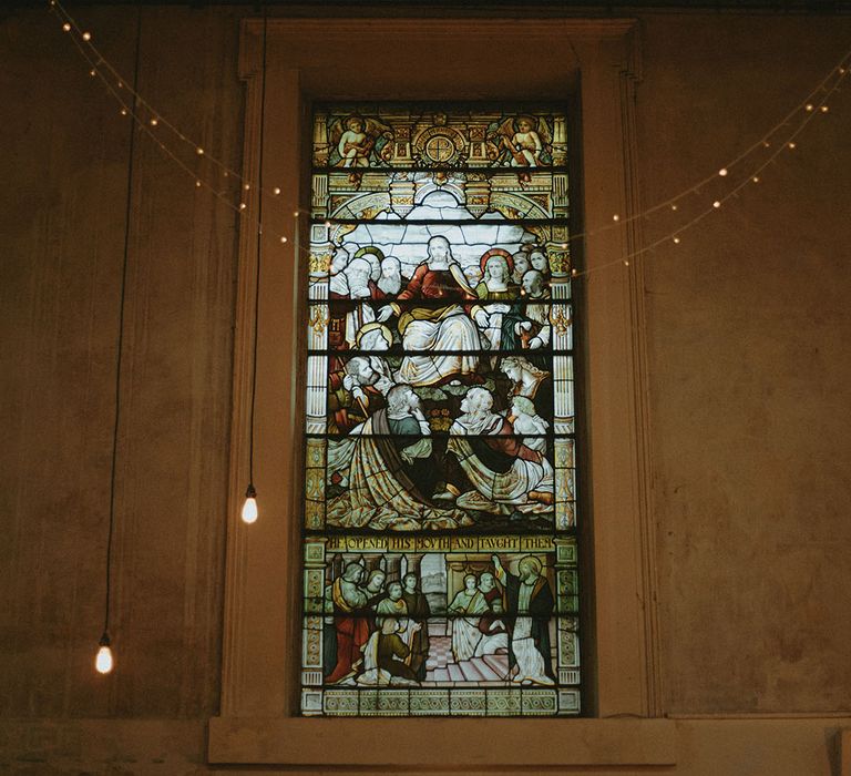 Stained glass windows at Freud wedding reception venue and fairy light decor