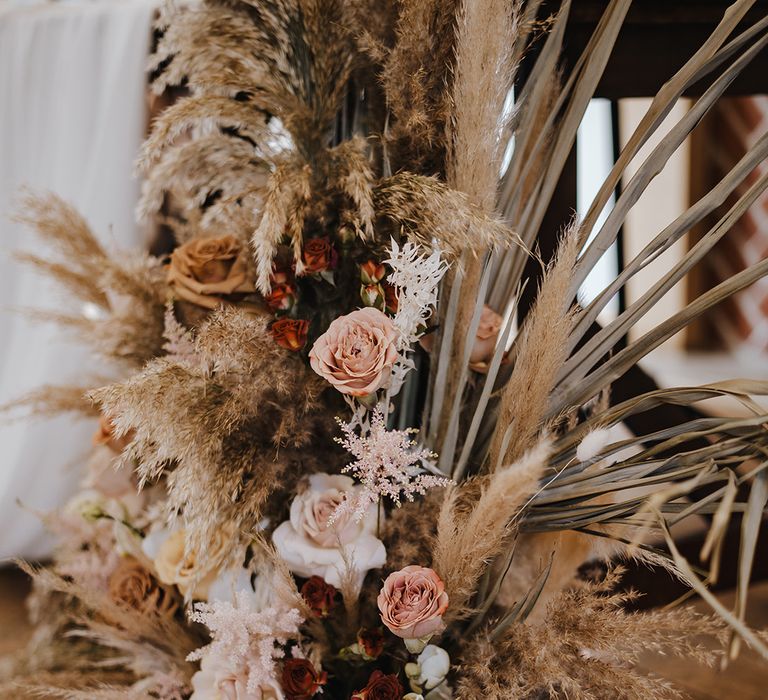 Pampas grass and rose neutral wedding flower display for aisle decoration at boho luxe wedding 