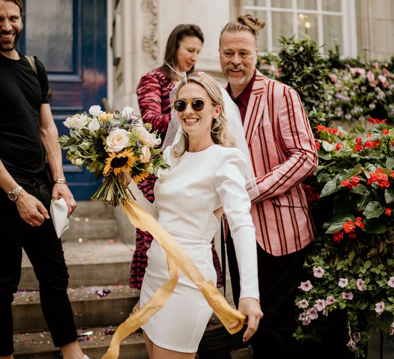 Bride in sunglasses and a short wedding dress for an intimate wedding at Chelsea Town Hall 