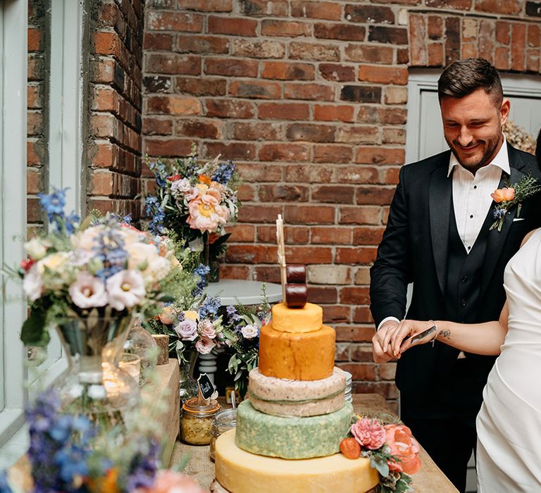 Bride and groom cut their cheese tower and celebrate