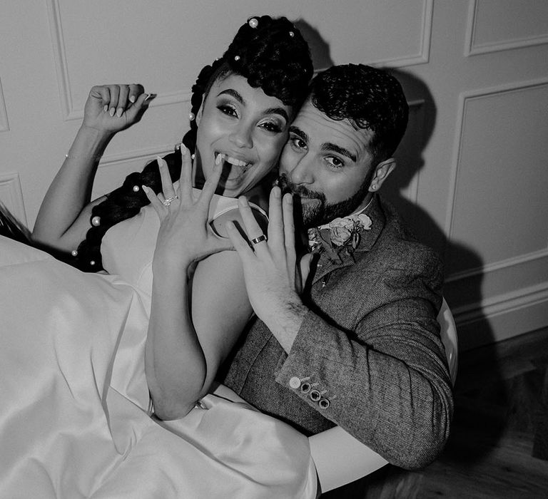 Bride & groom show off their wedding rings in black and white image at Pentney Abbey during reception 