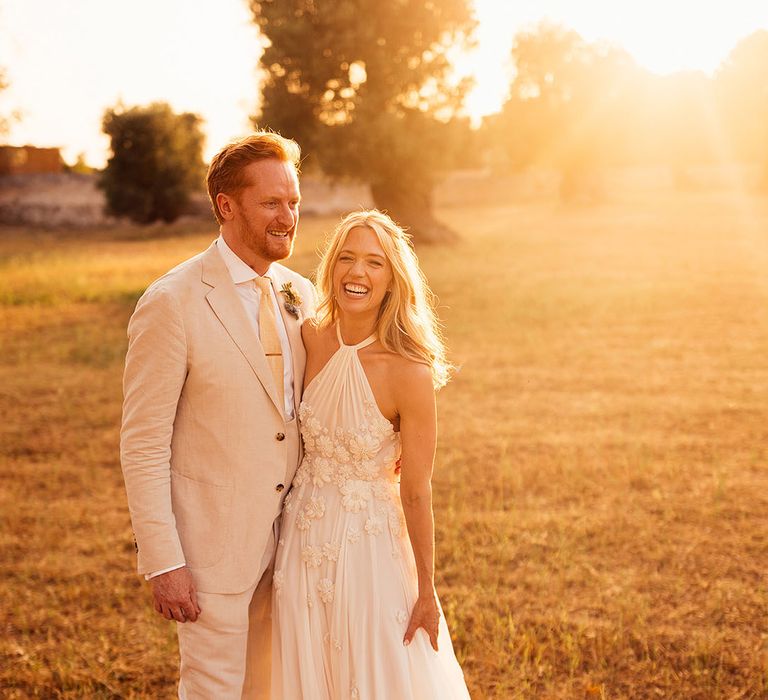 Golden hour couple portrait of the bride in an Emma Beaumont wedding dress and the groom in a cream suit 