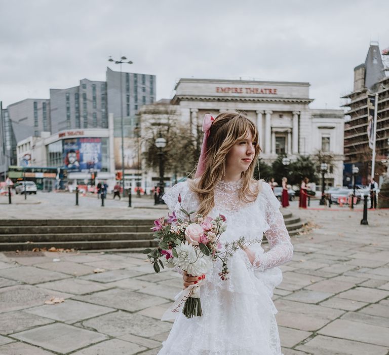 Ruffle lace long sleeve wedding dress with a pink bow hair accessory