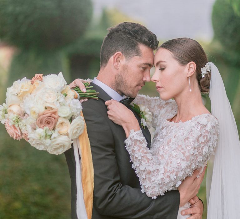 The bride and groom lean in to share an intimate moment together on their traditional and classic style day 