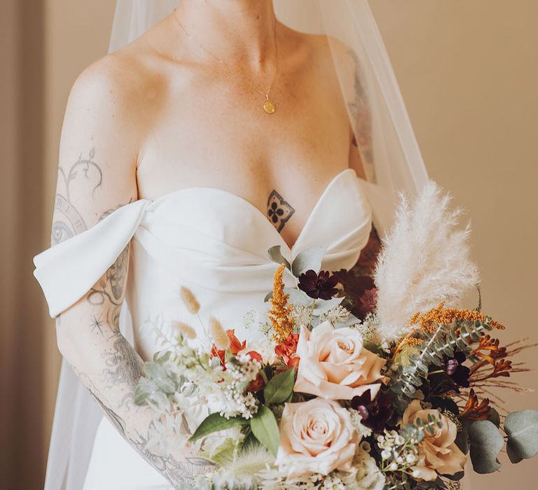 Bride wears red lipstick and Vera Wang wedding dress with sweetheart neckline and off-the-shoulder styling 