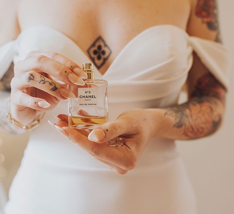 Bride holds Chanel No.5 perfume complete with french tip manicured nails