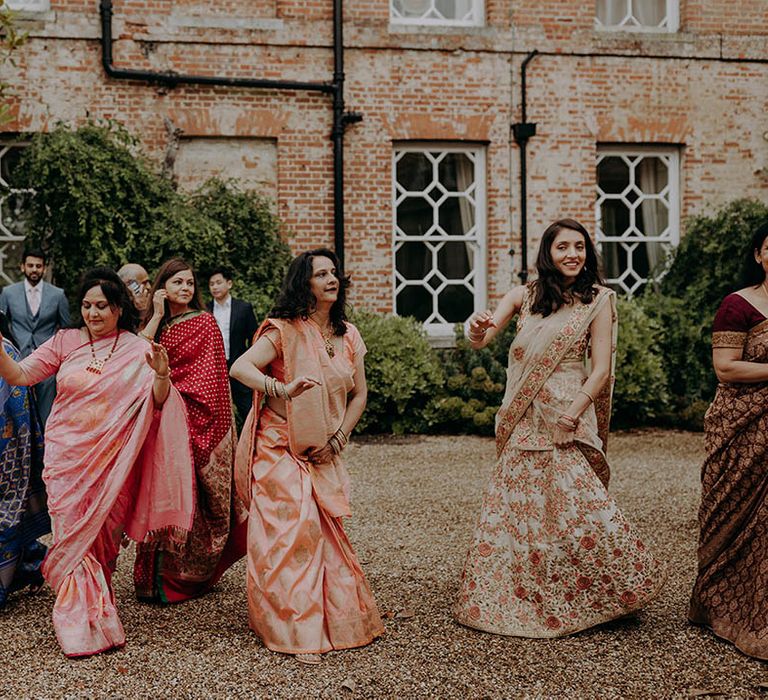 Wedding guests wear colourful outfits outdoors for Hindu wedding 