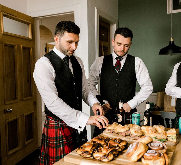 Grooms wear black waistcoats and tartan kilts 