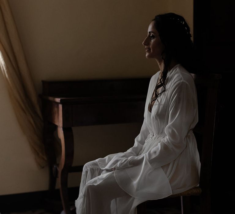 Bride wears white sheer silk dressing gown on the morning of her wedding day 