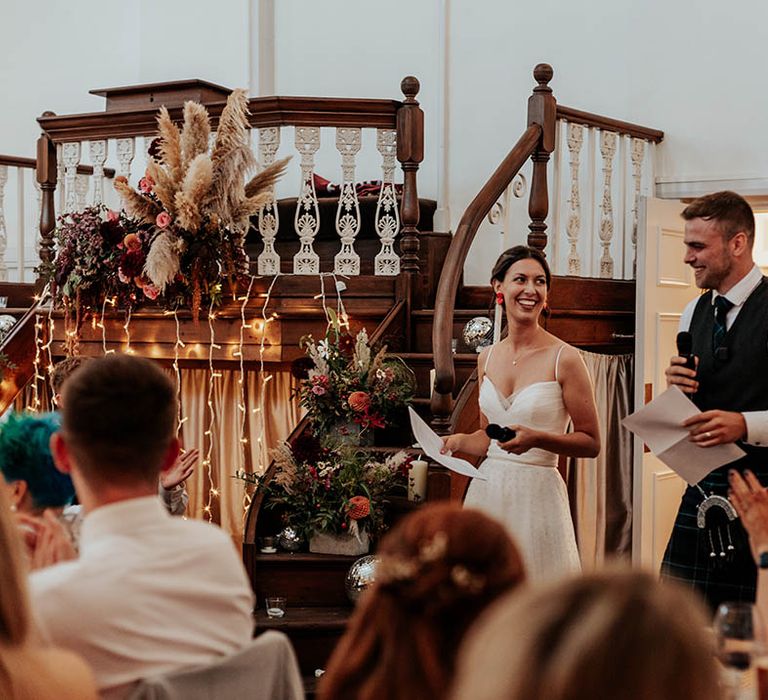 Boho wedding with bride and groom performing a joint wedding speech 