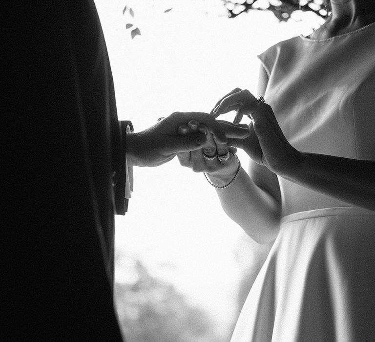 The bride and groom put on their wedding rings together as part of the civil wedding ceremony 