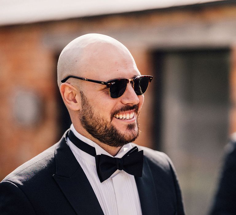 The groom in a black tuxedo with black sunglasses for Old Gore Barn wedding 