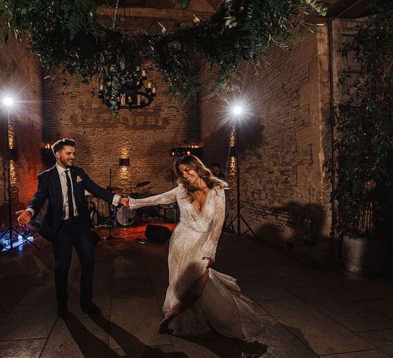 The bride and groom have their first dance together at their winter wedding at Stone Barn wedding venue in Cheltenham