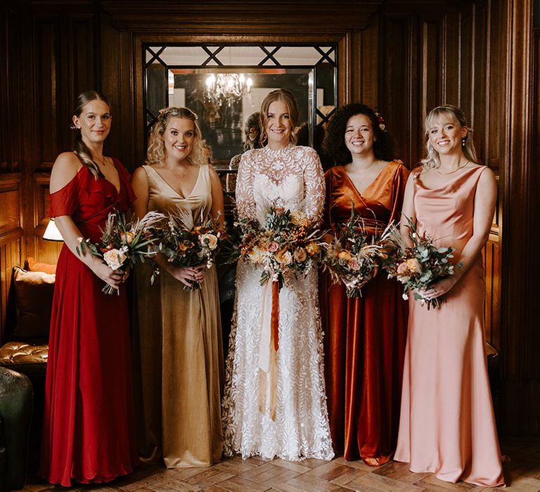 Bridesmaids in mismatched bridesmaid dresses in autumnal colours for October wedding at Wyresdale Park