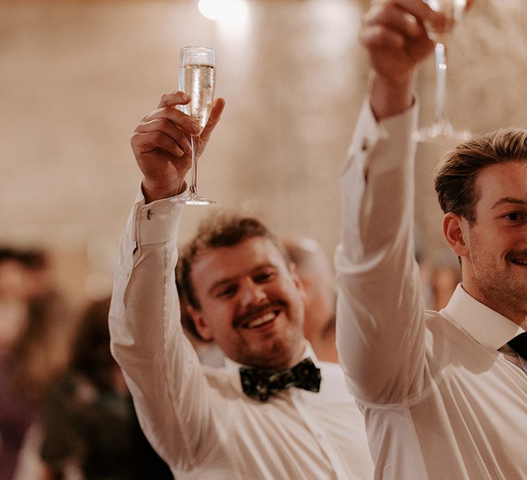 The groomsmen all raise their drinks in a toast during the speeches 