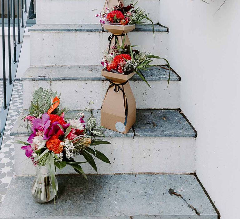 Colourful tropical African flower arrangements in cardboard boxes and glass vases 