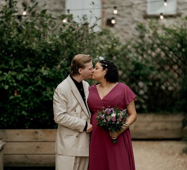 Bridesmaid in a burgundy wedding dress with her partner on the wedding day 