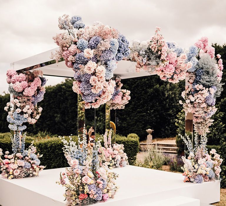 Mirrored outdoor wedding set up with pastel wedding flowers arrangements 