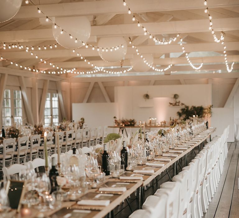 long banquet tables and fairy light wedding decor at riding school wedding 