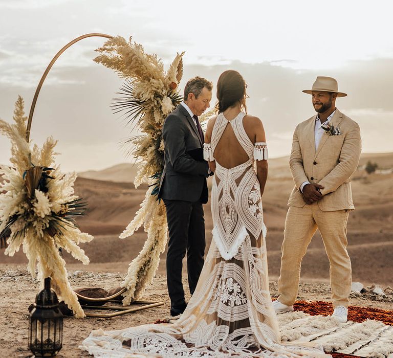 Bride in boho lace halter neck wedding dress with the groom at a destination wedding 