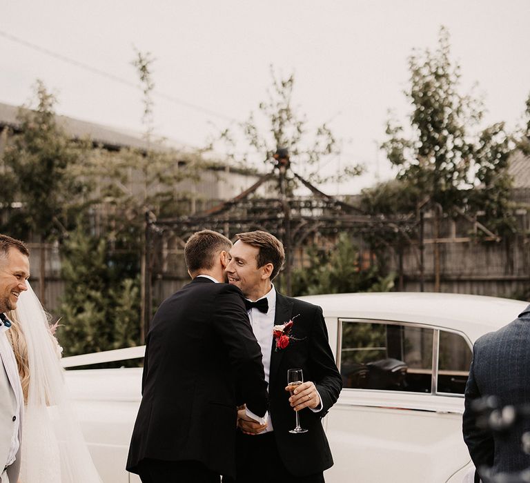 Groom and groomsmen wearing black tie wedding fashion for Valentine's wedding 