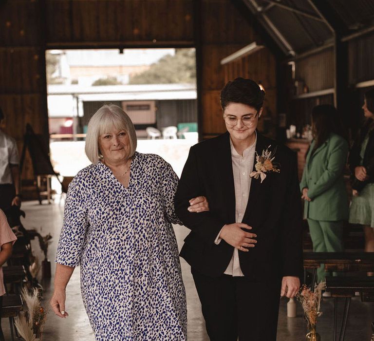 Mother of the bride wearing a casual printed dress walking bride down the aisle at The Giraffe Shed venue