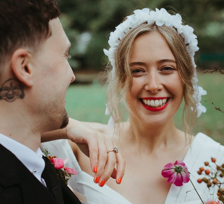 Bride wearing floral headband with orange squoval short nails for wedding 